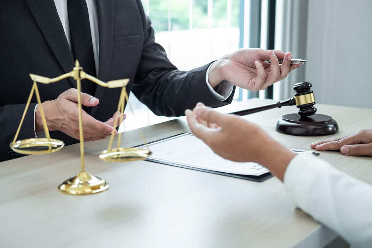 Coalinga Lawyer with gavel and scales of justice, discussing a personal injury case with a client.