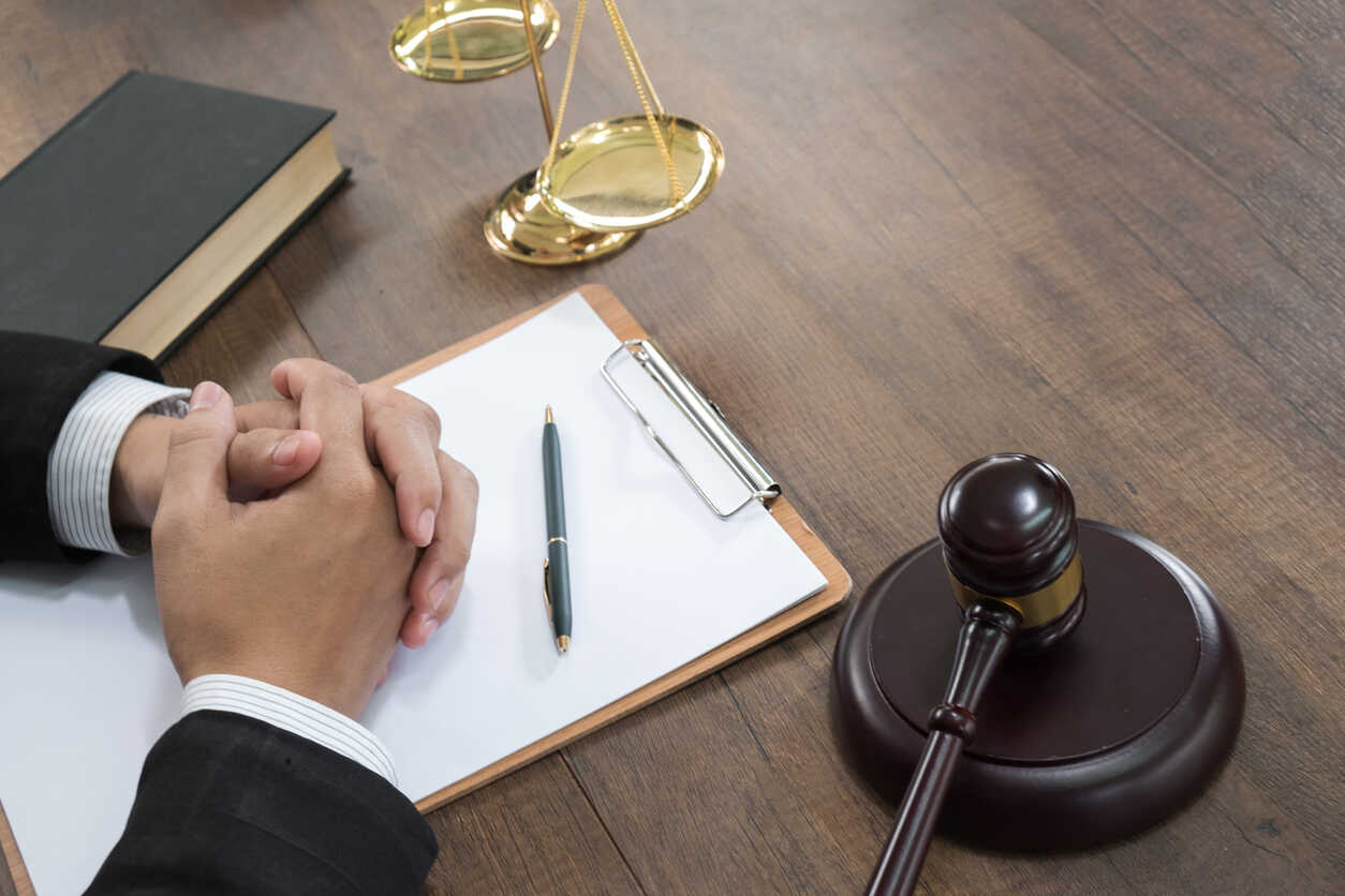Lawyer's hands clasped with a gavel and scales of justice, symbolizing personal injury legal services.
